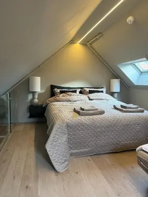 a bedroom with a large bed in a attic at Central apartment in idyllic Bakklandet in Trondheim