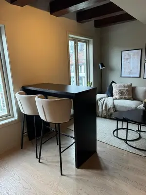 a black table and chairs in a room with a couch at Central apartment in idyllic Bakklandet in Trondheim