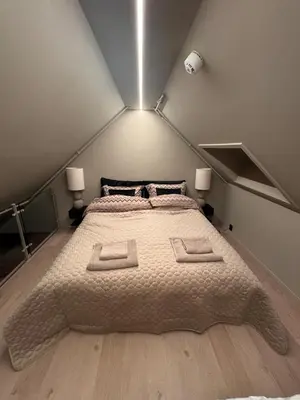 a large bed in a small room with two lamps at Central apartment in idyllic Bakklandet in Trondheim