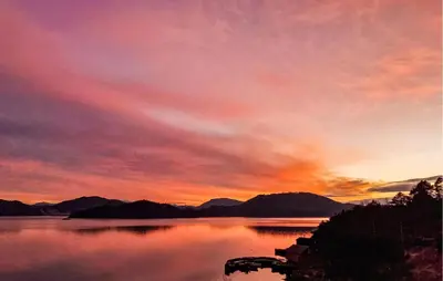 a sunset over a body of water with mountains at 3 Bedroom Lovely Home In Valen in Valen