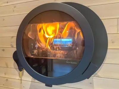 a fire in a fireplace in a wall at Modern Family Cabin at Norefjell - Views and Hiking in Eggedal