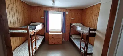 a room with three bunk beds and a window at Haugen Gård in Oppdal