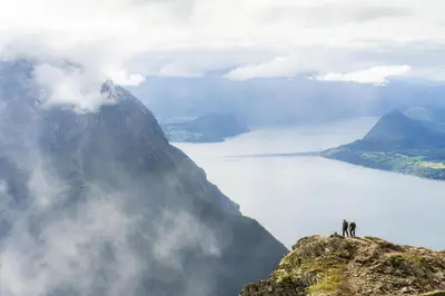 two people standing on top of a mountain at The Crux Nordic Design Mountain Cabin in Åndalsnes