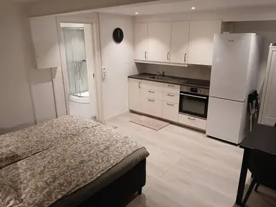 a kitchen with a bed and a white refrigerator at studio apartment 24 sqm in Trondheim
