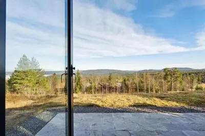 a glass door with a view of a field at The Holiday - Panorama Lodge in Lampeland