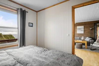 a bedroom with a bed and a large window at Lovely apartment with amazing view and sauna in Skulestadmo