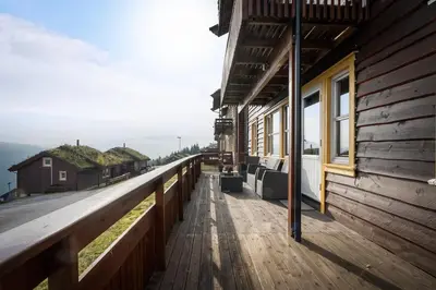 a wooden walkway next to a building with a view at Lovely apartment with amazing view and sauna in Skulestadmo