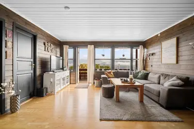 a living room with a couch and a table at Lovely apartment with amazing view and sauna in Skulestadmo