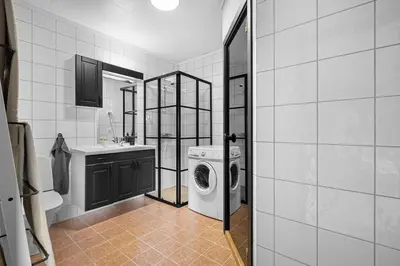 a bathroom with a washing machine and a sink at Lovely apartment with amazing view and sauna in Skulestadmo