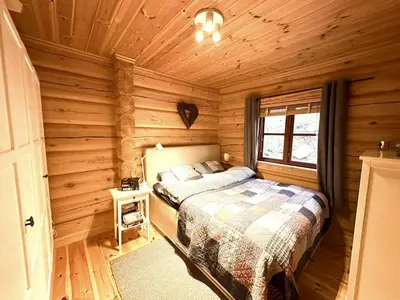 a bedroom with a bed in a log cabin at Siribu in Vågsli