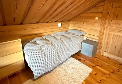 a bedroom with a bed in a wooden room at Siribu in Vågsli