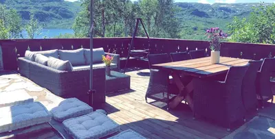 a wooden deck with a table and chairs on it at Siribu in Vågsli
