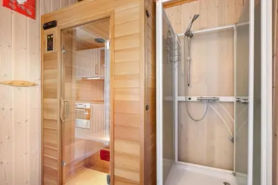 a shower with a glass door in a bathroom at Peaceful Cabin With Spa On Osterøy in Bruvik