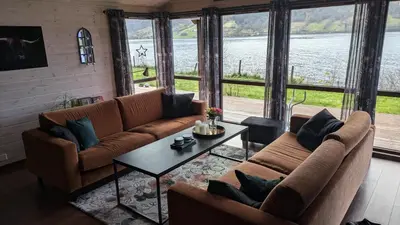 a living room with two couches and a table at Flott hytte i Vistdal, Romsdal in Myklebostad