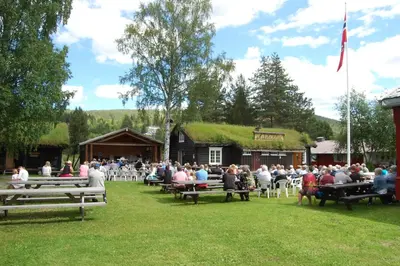 a large crowd of people sitting on benches in a park at Stor-Elvdal Hotell in Koppang