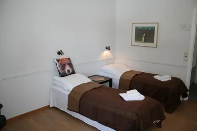 two beds in a hotel room with towels on them at Stor-Elvdal Hotell in Koppang