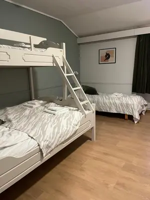 two bunk beds in a room with wood floors at Stor-Elvdal Hotell in Koppang