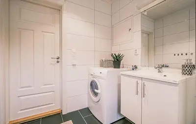 a white bathroom with a washing machine and a sink at Family Cabin With Ski Inout In Rauland in Rauland