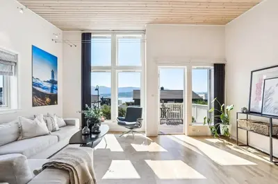 a living room with a couch and a chair at Moderne rekkehus nært Ålesund in Valderøya