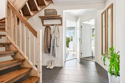 a hallway with white walls and wooden stairs and a hallway with a hallway at Moderne rekkehus nært Ålesund in Valderøya