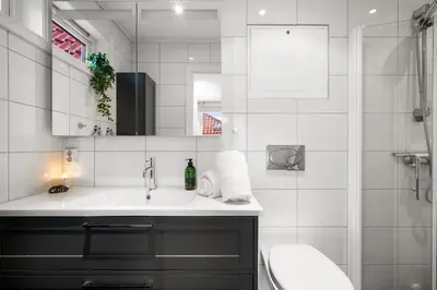 a bathroom with a sink and a mirror and a toilet at Scandinavian Hideaway I Private Balcony in Bergen
