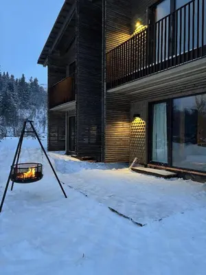 a house in the snow in front of a building at Architect Designed Mountain Cabin At Kvitfjell in Favang
