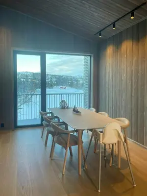 a dining room with a table and chairs and a large window at Architect Designed Mountain Cabin At Kvitfjell in Favang