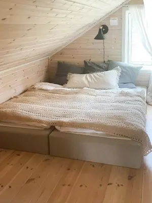 a large bed in a room with a wooden ceiling at Charming Cabin In Jotunheimen in Vaga