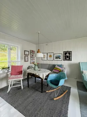 a living room with a table and two chairs at Peaceful Log Cabin By The Fjord On Ytterøy in Ytteroy