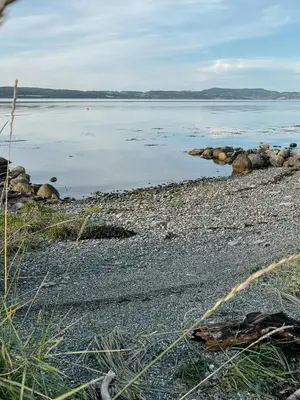 a large body of water with rocks on the shore at Peaceful Log Cabin By The Fjord On Ytterøy in Ytteroy