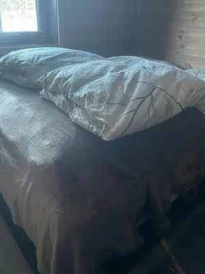 an unmade bed in a room with a window at Mountain Cabin With Panoramic Views In Savalen in Tynset