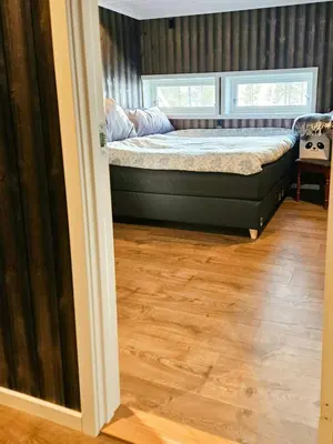 a bedroom with a bed and a wooden floor at Modern Cabin With Panoramic Views Near Langedrag in Tunhovd