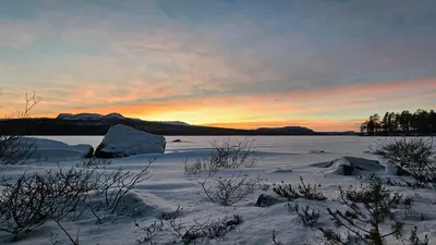 a snowy field with a sunset in the background at Modern Cabin With Panoramic Views Near Langedrag in Tunhovd