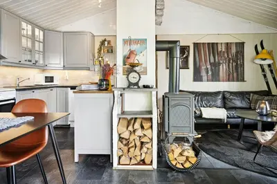 a kitchen and a living room with a wood stove at Cosy Cabin With Annex At Blefjell in Kongsberg