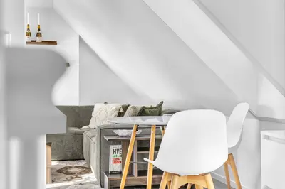 a living room with a table and two white chairs at Penthouse Apartment in Bergen