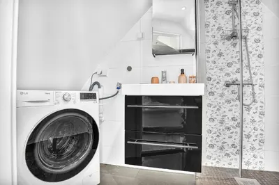 a washing machine in a bathroom with a shower at Penthouse Apartment in Bergen