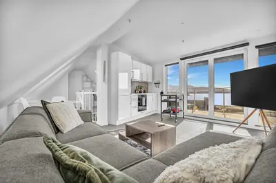 a living room with a couch and a flat screen tv at Penthouse Apartment in Bergen
