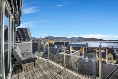 a balcony with a chair on a house at Penthouse Apartment in Bergen