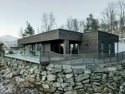 a house on top of a stone wall at Fjord Cabin With Panoramic Views In Rauma in Innfjorden