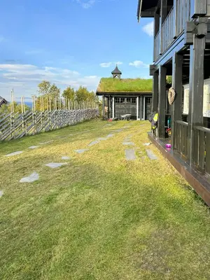 a yard next to a building with a grass roof at Mountain Cabin With Panoramic Views At Hummelfjell in Os
