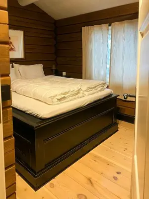a bed in a room with a wooden floor at Mountain Cabin With Panoramic Views At Hummelfjell in Os