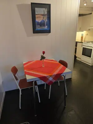 a table with a vase with a flower on it at Hagestova in Volda