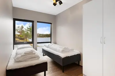 two beds in a room with a window at High-End Villa with Private rooftop and sea line in Bergen