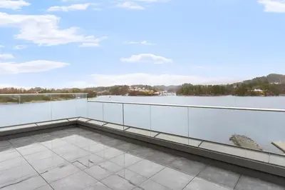 a balcony with a view of a body of water at High-End Villa with Private rooftop and sea line in Bergen