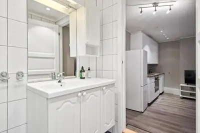 a white kitchen with a sink and a refrigerator at Apt 500 m to Bryggen - Perfect location in Bergen