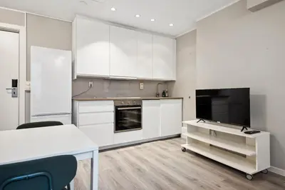 a kitchen with white cabinets and a table and chairs at Apt 500 m to Bryggen - Perfect location in Bergen