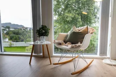 a room with a chair and a table and a window at Apartment with stunning fjord view near Ålesund in Ålesund
