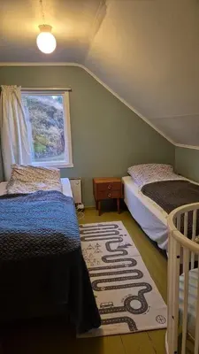 a bedroom with two beds and a window at Nygjerdet Gossen in Gossa
