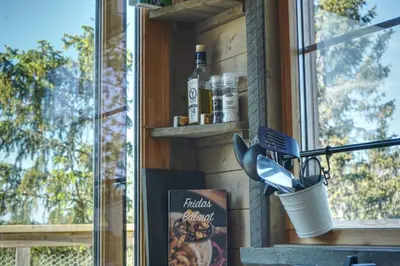 a window sill with a toothbrush holder and a book at Faråsen Luxury Treetop Cabin - Sleep Among the Trees in Ringsaker