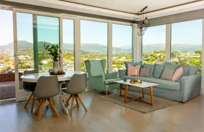 a living room with a couch and a table with chairs at Hytte Hammarslandbakken in Bergen